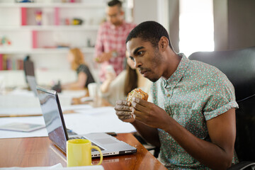 Man eating and working at conference tablet