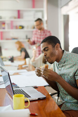Man eating and working at conference tablet