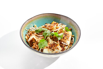 Pan asian traditional dish - fried rice with egg, vegetables, and squid. Indian wok with rice, egg and kalmar on white background. Nasi goreng with calamari on isolated background with shadows. © Ryzhkov