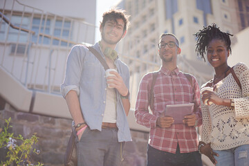 Friends using digital tablet on city street