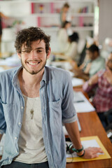 Man leaning on desk in office