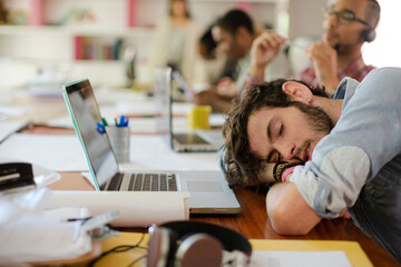 Man sleeping at desk in office