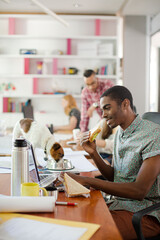 Man eating and working at conference tablet