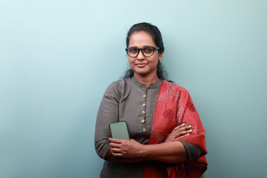 Woman Of Indian Ethnicity Holding A Mobile Phone With A Smiling Face 