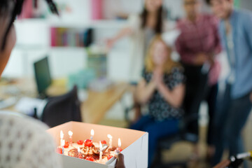 People celebrating birthday in office