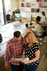 People reading folders in office