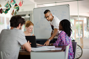 Man drawing on white board for colleagues