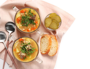 Bowls with tasty beef barley soup on white background