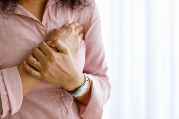 Adult woman with sudden heart attack and use hand hold chest with distorted face. Concept of...