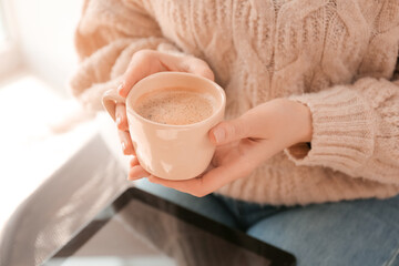 Young woman with cup of coffee at home