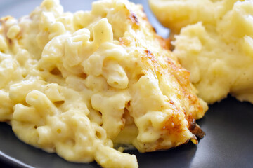 Macaroni and cheese with mashed potato on a plate. 