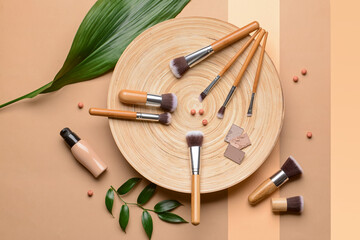 Naklejka premium Set of makeup brushes with decorative cosmetics on color background