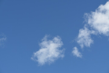 Light and fluffy white clouds, or cumulus, in bright blue sky