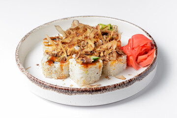 Tuna sushi in white dish served with wasabi sauce, pickled ginger. Over white background.
