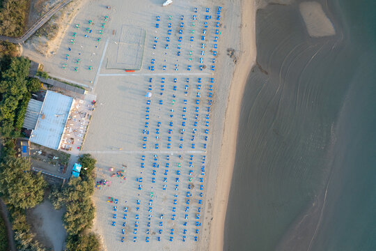 Aerial view of sandy beach with umbrellas and gazebos.Summer vacation concept.Lido Adriano town,Adriatic coast, Emilia Romagna,Italy.