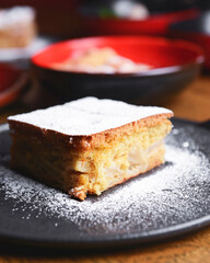 One piece of cheesecake served with s lot of different dessert in plates on a wooden table.