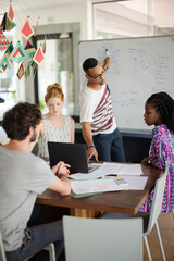 Man drawing on white board for colleagues