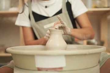 Artisan making clay vessel in studio