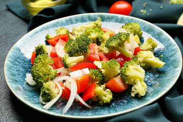 Plate of tasty salad with broccoli on dark background, closeup