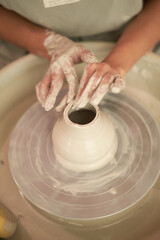 Master making ceramic vase on pottery wheel