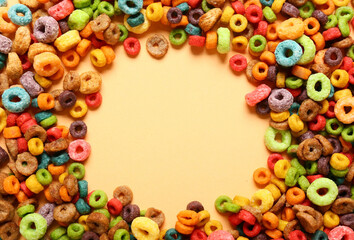 Frame made of tasty cereal rings on color background, closeup