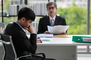 Asian businessman office workers sitting with serious emotions because he was blamed by a senior...