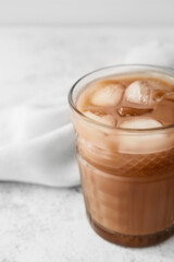 Glass of tasty chocolate milk on light background, closeup
