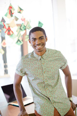 Man leaning on desk in office