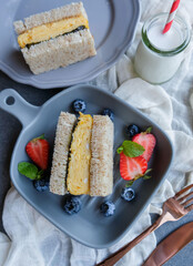 Homemade Japanese breakfast meal. Tamagoyaki Rolled Egg Crispy Seaweed  Sandwich with Wasabi. Wholemeal bread, pan fried rolled egg, seaweeds, wasabi paste, strawberry and blueberry with fresh milk.