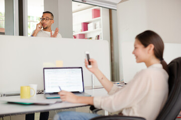 Woman using cell phone in office