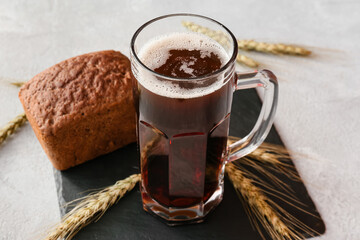 Mug of fresh kvass on light background