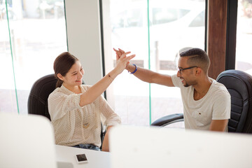 People high fiving in office