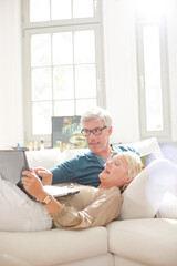 Older couple relaxing together on living room sofa