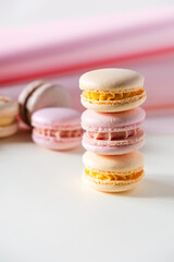 Colorful pastel french macaroons or macarons  on white and pink background