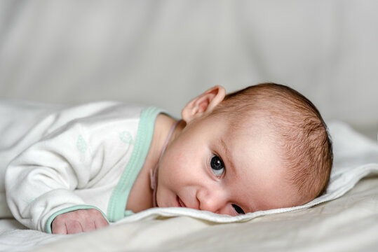 A newborn charming baby in white. Close-up portrait.