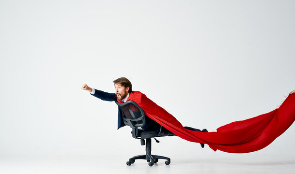 a man in a red cloak suit ride in a chair superheroes