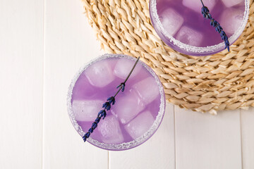 Glasses of fresh cocktail with lavender on light wooden background, closeup