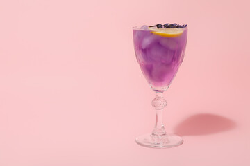 Glass of fresh cocktail with lavender on color background
