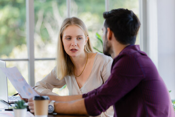 Two businesspeople, man and woman, working together in a modern office in an intimate manner. Idea for teamwork and good business colleagues