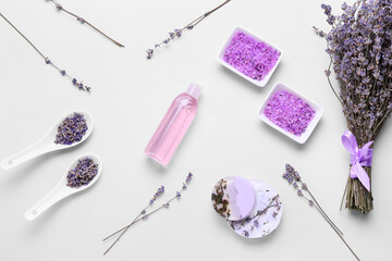 Composition with soap, sea salt, bottle of cosmetic product and lavender flowers on white background
