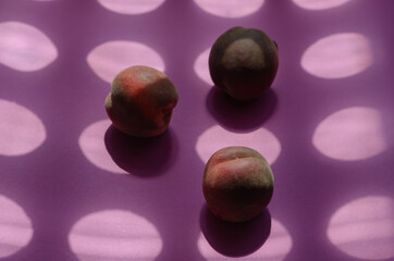 Geometric composition with peaches and round shadows. Three ripe