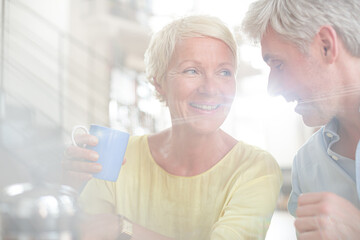 Older couple hugging with coffee cup