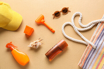 Set of beach accessories for children, bottles of sunscreen and seashell on color background