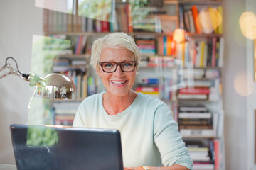 Businesswoman smiling at computer in home office