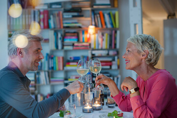 Older couple toasting each other at romantic dinner