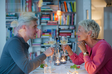 Older couple toasting each other at romantic dinner