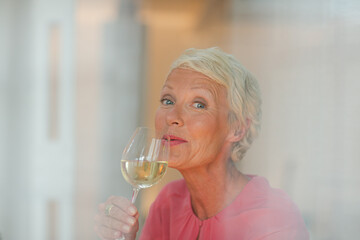 Older woman drinking glass of white wine