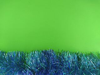 Vibrant glowing tinsel on green background
