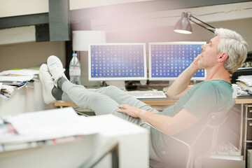 Fototapeta premium Businessman talking on cell phone at office desk