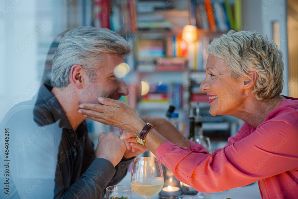 Wall mural Older man kissing hand of wife at romantic dinner